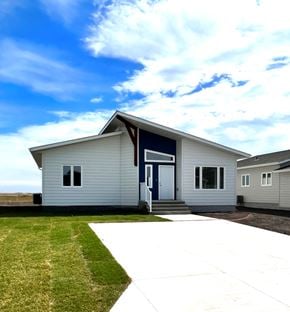Brandon apartment for rent - A small white house with a blue door and windows.