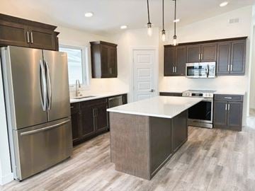 Brandon apartment for rent - A modern kitchen with a stainless steel refrigerator and dark brown cabinets.