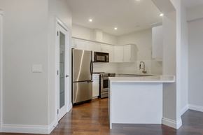 Edmonton apartment for rent - a kitchen with white cabinets and a stainless steel refrigerator