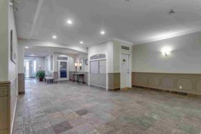 Edmonton apartment for rent - the lobby of a building with a large lobby area and a table with chairs