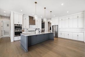 Boise house for rent - a large kitchen with white cabinets and a large island