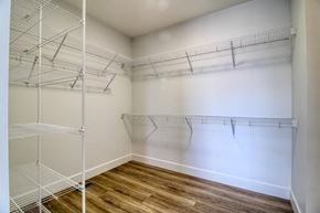 Vernon house for rent - a spacious walk in closet with white walls and wood flooring