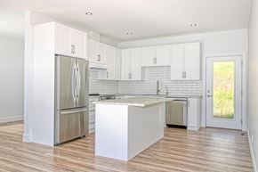 Vernon house for rent - a kitchen with white cabinets and a stainless steel refrigerator