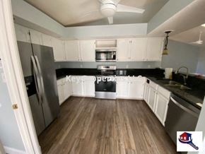 Loudon house for rent - A kitchen with a black stove top oven and white cabinets.