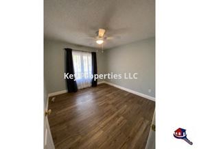 Loudon house for rent - A room with wooden flooring and a ceiling fan, with the text "Key Properties LLC" and a logo.
