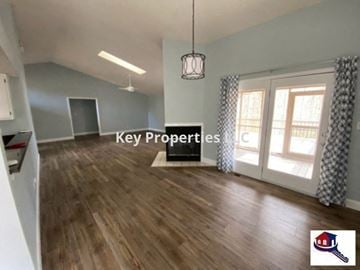 Loudon house for rent - A room with wooden floors and a hanging light fixture.