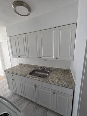 Vero Beach apartment for rent - A kitchen with a granite countertop and white cabinets.