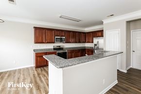 Monroe house for rent - a kitchen with granite counter tops and wooden cabinets
