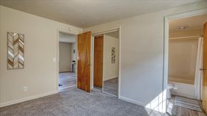 Spokane Valley apartment for rent - A room with a wooden door and a white wall with a picture on it.