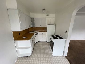 Spokane apartment for rent - A kitchen with white cabinets and a white refrigerator.