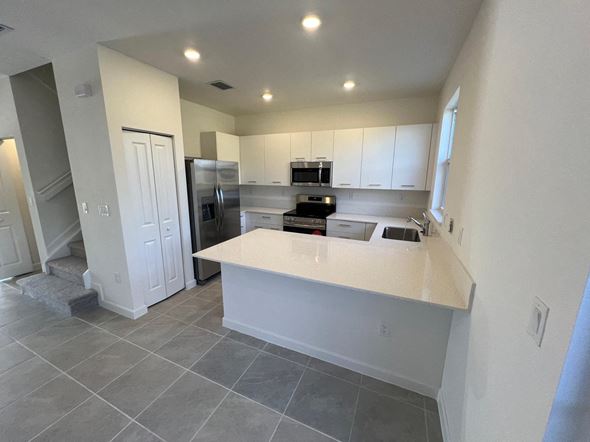 Miami Shores house for rent - a kitchen with white cabinets and a counter top