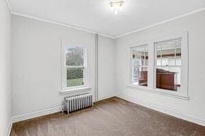 Whiting apartment for rent - an empty room with a radiator and two windows
