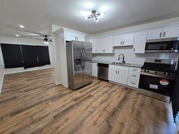 Gary house for rent - a kitchen with stainless steel appliances and white cabinets