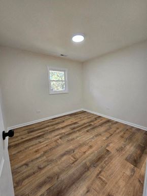 Gary house for rent - an empty room with wooden floors and a window