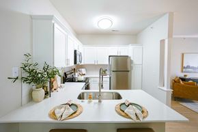 Greenwood apartment for rent - A kitchen with white cabinets and a wooden floor.