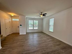 Greenville house for rent - a living room with white walls and a ceiling fan