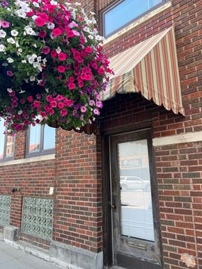 Grinnell apartment for rent - A building with a striped awning and a door with a window above it.