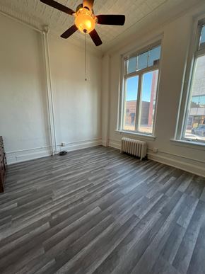 Grinnell apartment for rent - A room with a ceiling fan and a radiator on the wall.