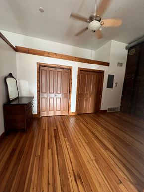 Grinnell apartment for rent - A room with wooden floors and a ceiling fan.