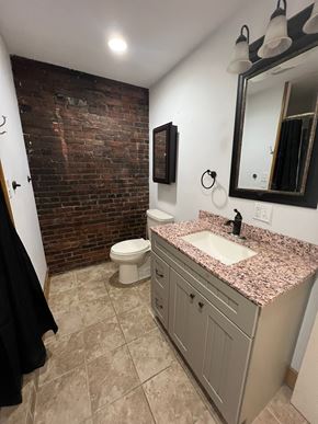 Grinnell apartment for rent - A bathroom with a brick wall and a sink.