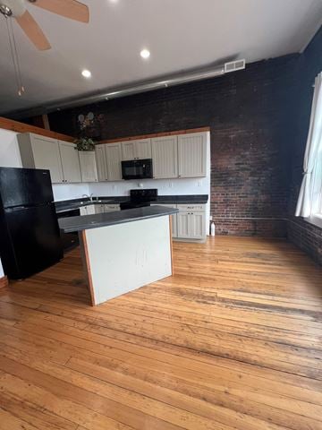 Grinnell apartment for rent - A kitchen with a black fridge and white countertops.