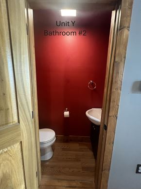 Grinnell apartment for rent - A bathroom with a red wall and a white toilet.