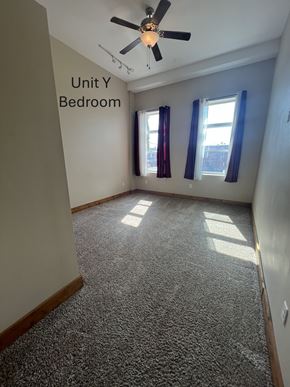 Grinnell apartment for rent - A bedroom with a carpeted floor and a ceiling fan.