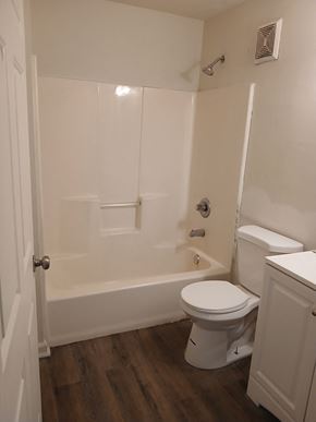 Louisville apartment for rent - A white toilet sits in a bathroom next to a bathtub.