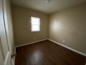 Louisville house for rent - A room with a wooden floor and a window.