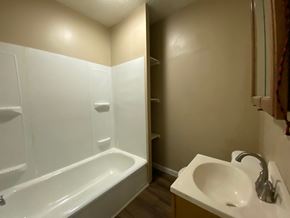 Louisville house for rent - A white bathroom with a bathtub, sink, and towel rack.
