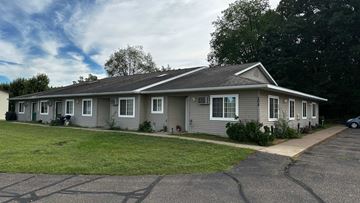 Menomonie apartment for rent - A grey house with a grey roof and a grey car parked in front.