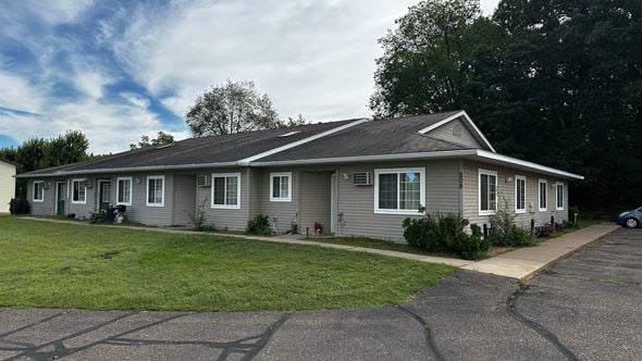 Menomonie apartment for rent - A grey house with a grey roof and a grey car parked in front.