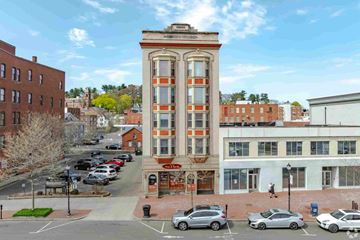 New Britain apartment for rent - A tall building with a red and white striped facade stands in the middle of a parking lot.