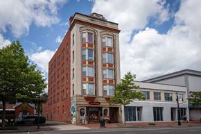 New Britain apartment for rent - A tall red brick building with a white trim and a red awning on the front.