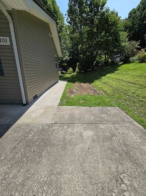 Morehead house for rent - a driveway in front of a house with a lawn and trees