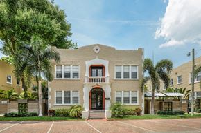 Tampa apartment for rent - a large brick house with palm trees in front of it