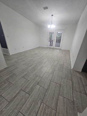 Pensacola house for rent - the living room and dining room of an empty home with tile flooring