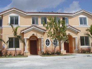 Homestead house for rent - a large house with palm trees in front of it