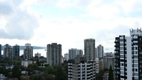 Vancouver apartment for rent - A cityscape with tall buildings and a cloudy sky.