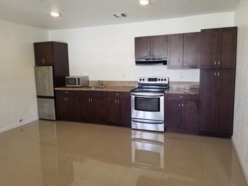 Hallandale apartment for rent - A kitchen with brown cabinets and a stainless steel oven.