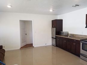 Hallandale apartment for rent - A kitchen with white walls and brown cabinets.