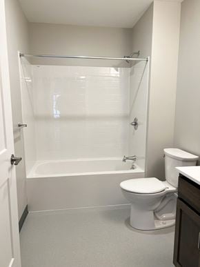 Agawam apartment for rent - A white toilet sits next to a bathtub in a bathroom.