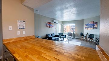 Albuquerque apartment for rent - A living room with a wooden floor and a dining table with chairs.