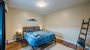 Albuquerque apartment for rent - A bedroom with a bed, nightstand, and a ladder.