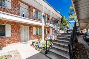 Albuquerque apartment for rent - A red brick building with a white door and a balcony.