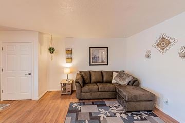Albuquerque apartment for rent - A living room with a brown couch and a lamp on a side table.