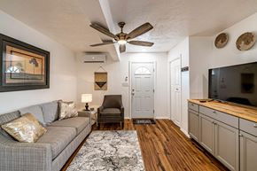 Albuquerque apartment for rent - A living room with a grey couch and a ceiling fan.