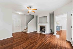 Fuquay-Varina house for rent - a living room with a fireplace and a ceiling fan