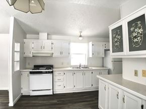 Manvel house for rent - a white kitchen with white cabinets and white appliances