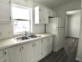 Manvel house for rent - an empty kitchen with white cabinets and a sink